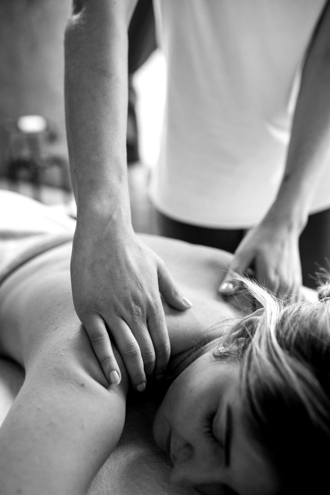 Black-and-white photo of a calming shoulder massage session.